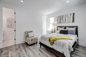 a white bedroom with a bed and a chair at Nature's Touch in Edisto Island