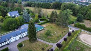 an aerial view of a house with a pool in a yard at La Ferrière in Pissy-Pôville