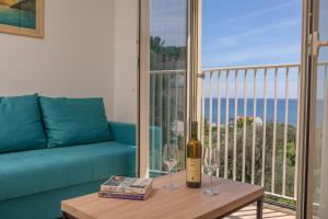 a living room with a couch and a wine bottle on a table at Apartments Bonazza in Petrovac na Moru