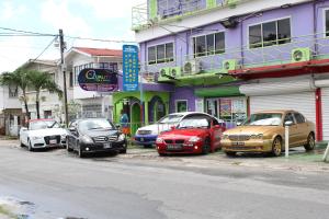 un gruppo di auto parcheggiate di fronte a un edificio di PG Quality Inn a Georgetown