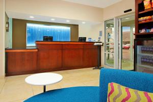 una sala de espera con caja registradora y sofá azul en Fairfield Inn & Suites Colorado Springs South en Colorado Springs