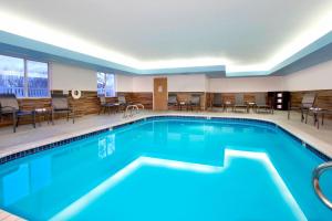 uma piscina num quarto de hotel com cadeiras e mesas em Fairfield Inn & Suites Colorado Springs South em Colorado Springs