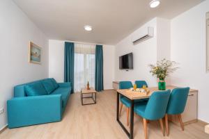 a living room with a blue couch and a table at Apartments Bonazza in Petrovac na Moru