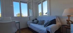 uma sala de estar com um sofá azul e janelas em Port 3 em Tarragona