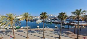 uma marina com palmeiras e barcos na água em Port 3 em Tarragona