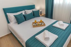 a bedroom with a blue and white bed with a tray of food at Apartments Bonazza in Petrovac na Moru