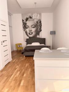 a bedroom with a bed with a painting of a woman at Apartament MARILYN w Kamienicy Wicherkiewiczów in Poznań