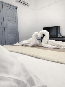 2 cigni seduti su un letto in una camera da letto di Diamond's House a Kallithea