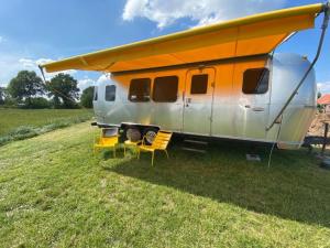 Ein Wohnwagen mit einem orangenen Dach auf einem Feld in der Unterkunft Rusttheater, genieten van rust en ruimte in Reutum