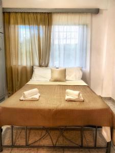 a bed with two towels on it in front of a window at Diamond's House in Kallithea Halkidikis