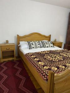 1 dormitorio con cama de madera y almohadas en Casuta Bunicilor Corbii de Piatra, en Corbi
