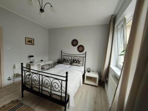 ein Schlafzimmer mit einem schwarzen Bett in einem weißen Zimmer in der Unterkunft Apartament Armii Krajowej Sopot 71 in Sopot
