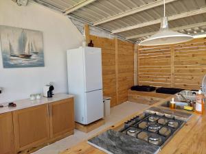 una cocina con nevera blanca y un barco en la pared en COMPORTA SIDE - Tents, en Setúbal