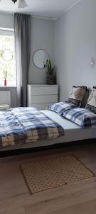 a bedroom with a bed with a blue blanket and a window at Apartament Armii Krajowej Sopot 71 in Sopot