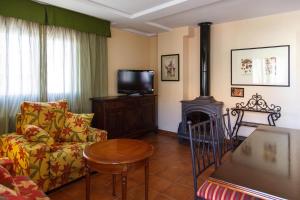 Il comprend un salon doté d'un canapé, d'une télévision et d'une cheminée. dans l'établissement Apartamentos turísticos el gamo, à Tragacete