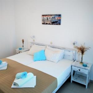 a bedroom with a large white bed with towels on it at Dolphin Rooms in Antiparos