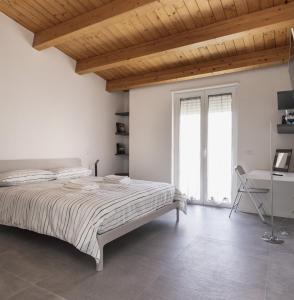 Habitación blanca con cama y escritorio en Come a casa - Feels like home, en Polignano a Mare