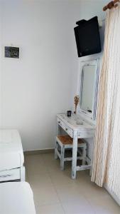 a room with a desk with a mirror and a tv at Dolphin Rooms in Antiparos