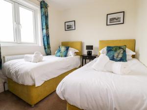 two beds in a room with two windows at Number 37 in Bude