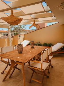 a wooden table and chairs in a room with an umbrella at La Mansarda degli Ulivi in Portoferraio
