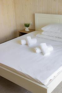 Elle comprend un grand lit blanc avec des oreillers blancs. dans l'établissement Lotus & Spa, à Solotvyno