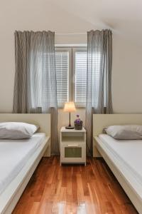 a bedroom with two beds and a lamp on a night stand at Zara 1 in Kruševo