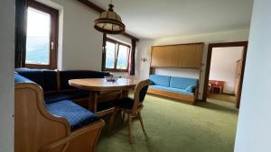 a living room with a table and a blue couch at Haus Brandeck in Uttendorf