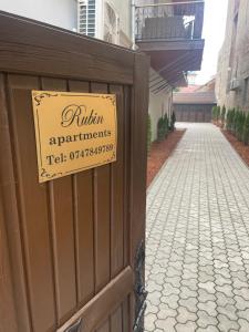 una señal en el lateral de una valla de madera en Rubin Apartments, en Gheorgheni