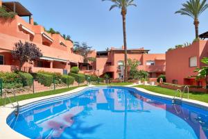 einen Pool in einem Resort mit Palmen in der Unterkunft Sea Suite in Marbella