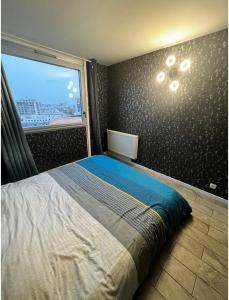 sypialnia z łóżkiem i dużym oknem w obiekcie Grand appartement proche métro quartier la defense w mieście Courbevoie