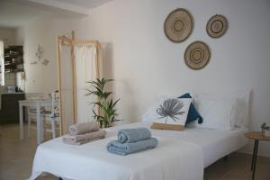 a bedroom with a white bed with towels on it at Fereniki's place in Gaios