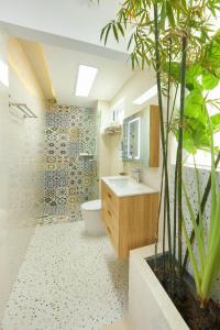 a bathroom with a sink and a toilet and a plant at Truc Home in Danang