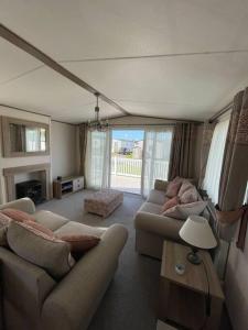 ウェアラムにある2-6 guests Holiday Home in Durdle Doorのリビングルーム(ソファ2台、テーブル付)