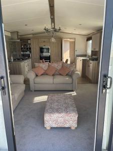 a living room with two couches and a table at 2-6 guests Holiday Home in Durdle Door in Wareham