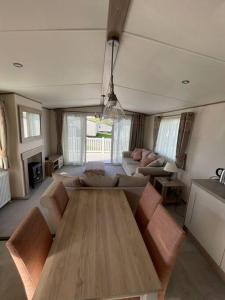 ウェアラムにある2-6 guests Holiday Home in Durdle Doorのリビングルーム(木製テーブル、ソファ付)