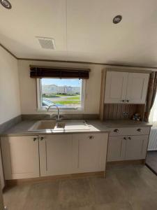 a small kitchen with a sink and a window at 2-6 guests Holiday Home in Durdle Door in Wareham