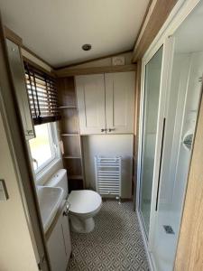 a small bathroom with a toilet and a sink at 2-6 guests Holiday Home in Durdle Door in Wareham