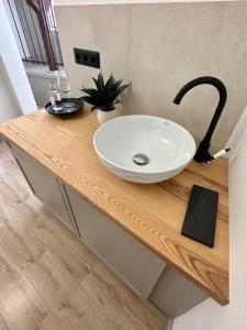 a white sink on a wooden counter in a bathroom at Hotel Kocour in Třebíč