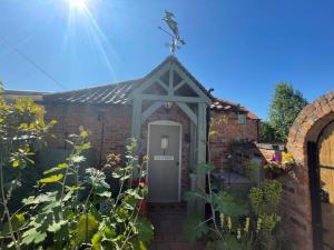 a brick house with a door in a garden at The Retreat in Doncaster