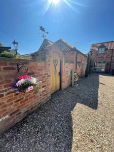 een bakstenen gebouw met een houten deur en bloemen bij The Retreat in Doncaster