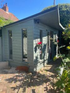 a small blue house with flowers in a yard at The Retreat in Doncaster