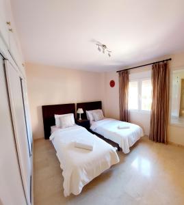 a bedroom with two beds and a window at Luxurious Apartment 2 Bedroom 2 Bathroom Near Beach in Málaga