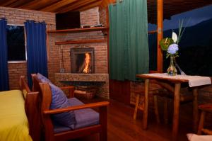 Una chimenea en una habitación con una cama y una mesa. en Pousada Chales Recanto do Sossego, en Visconde De Maua