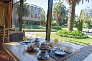 a wooden table with food and glasses of orange juice at Sheraton Pilar Hotel & Convention Center in Pilar