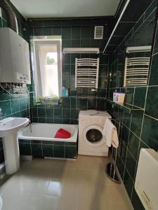 a green tiled bathroom with a toilet and a sink at Apartament Armii Krajowej Sopot 71 in Sopot