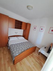 Sunce Mobile Homes & apartments في غريباستيكا: غرفة نوم بسرير كبير وارضية خشبية