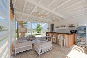 a kitchen and living room with a bar and chairs at Le Grancìe in Porto Cesareo