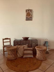 a room with a couch with two chairs and a suitcase at GIALOS APARTMENT in Elafonisos