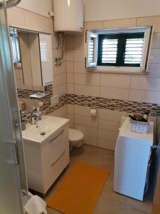 a bathroom with a sink and a toilet and a mirror at Matko 1 in Bol