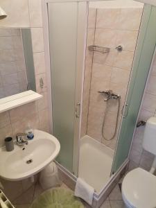 een badkamer met een douche, een wastafel en een toilet bij Matko 1 in Bol